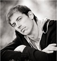 Schwarz-weiß Foto eines jungen Mannes, der verträumt in die Ferne schaut.