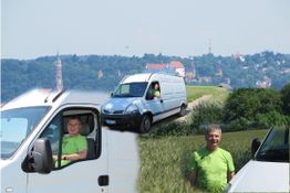 Mann mit grünem T-Shirt und weißem Transporter auf Feldweg, Stadt im Hintergrund.
