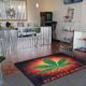 Cannabis store interior with a display counter and a large cannabis leaf rug on the floor.