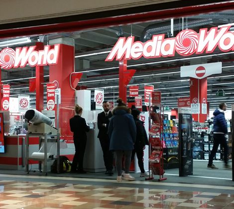 Ingresso di un negozio MediaWorld con persone che fanno acquisti e personale vicino all'entrata.