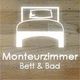 Symbol eines Bettes auf Holz, darunter der Text "Monteurzimmer Bett & Bad".