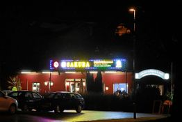 Außenansicht eines beleuchteten Gebäudes mit dem Schriftzug "Sakura" bei Nacht.