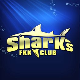 Logo mit gelbem Hai und Text "Sharks FKK Club" vor blauem Hintergrund mit Luftblasen.