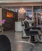 Moderner Friseursalon mit Waschtischen, Spiegeln und stilvollen Dekorationen unter Kronleuchtern.