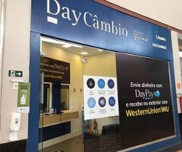 Loja de câmbio com fachada azul, destacando serviços de envio de dinheiro e Western Union.