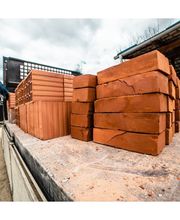 Ladrillos apilados en camión con una persona al fondo y cielo nublado.