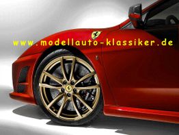 Roter Sportwagen mit goldener Felge und Logo, Text "www.modellauto-klassiker.de".