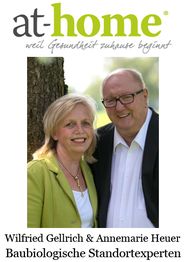 Paar lächelt im Freien, "at-home"-Logo darüber, Text darunter: Baubiologische Standortexperten.