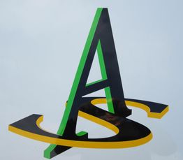 Buchstaben „A“ und „S“ in Schwarz mit grüner und gelber Kontur auf grauem Hintergrund.