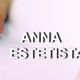 Mani curate e viso sorridente sopra la scritta "Anna Estetista" su sfondo sfumato rosa.