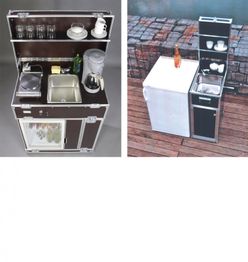 Kompakte Kücheneinheiten mit Spüle, Herd, Kühlschrank und Utensilien auf Holzdeck.