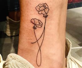 Tatoeage van twee eenvoudige bloemen op het onderbeen. Schoenen op de achtergrond.