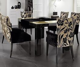 Esszimmer mit schwarzem Tisch und Stühlen mit floralem Muster in beige und schwarz.