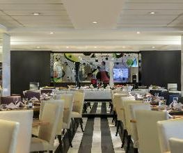 Restaurante elegante com mesas arrumadas e decoração moderna em tons neutros.