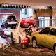 Tow truck hauling a vehicle in a snowy urban setting with icicles hanging above.