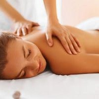Person receiving a relaxing back massage in a serene setting.