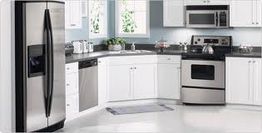 Modern kitchen with stainless steel appliances and white cabinets.