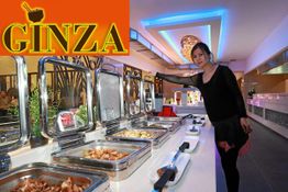 Eine Frau steht an einem Buffet in einem Restaurant namens Ginza.