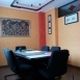 Sala riunioni con tavolo rettangolare, sedie nere e pareti colorate con opere d'arte.