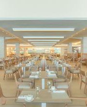 Un restaurante amplio, elegante y vacío con varias mesas y sillas organizadas.