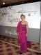 Eine Person in einem pinken Kleid steht vor einer Wand mit der Aufschrift "Harry's Bar".