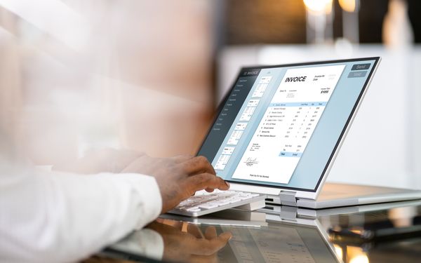 Eine Person bearbeitet eine E-Rechnung am Laptop.