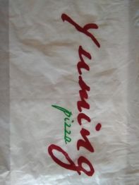Bolsa blanca con el texto "Yuming pizza" en rojo y verde.