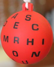 Pelota roja colgante con letras negras impresas en diversas orientaciones.