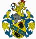 Wappen mit Löwen, Helm und blauer Banderole mit Blumenmotiven auf gelbem Schild.