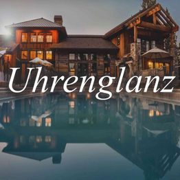 Luxuriöses Holzhaus mit Pool bei Sonnenuntergang, reflektiert im Wasser, Text "Uhrenglanz".
