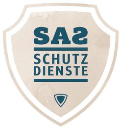 Ein Schild-Logo mit dem Text "SA2 Schutzdienste" in Blau auf beigem Hintergrund.