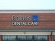 Sign on brick building reading "Polaris Dental Care" with a smiley face logo.