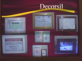 Certificados emoldurados em exposição na parede, com a palavra "Decorsil" ao topo.