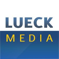 Logo mit dem Text "Lueck Media" in blauer und gelber Schrift auf weißem und blauem Hintergrund.