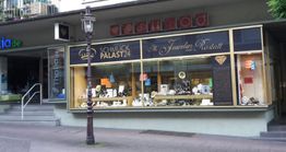 Juweliergeschäft in einer Stadt, Schaufenster mit Schmuckauslagen und Straßenlaterne davor.