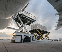 Carga siendo embarcada en un avión mediante plataformas elevadoras en el aeropuerto.