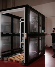Persona operando gran máquina en una sala con suelo rojo.