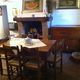 Sala da pranzo rustica con tavolo in legno, camino e mobili antichi. Decorazioni alle pareti.