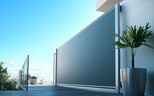 Terrasse mit Senkrechtmarkise und blauem Himmel. Im rechten Eck steht eine Topfpflanze.