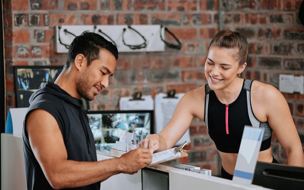 Kunde im Fitnessstudio unterschreibt einen Jahresvertrag.