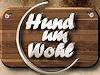 Holzbrett mit Schriftzug "Hund um Wohl" in weißer 3D-Schrift.