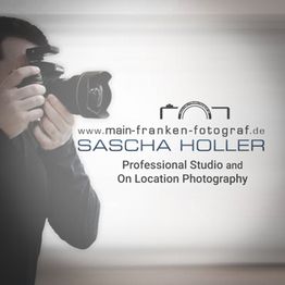 Fotograf mit Kamera, Text: "www.main-franken-fotograf.de Sascha Holler, Fotostudio und vor Ort".