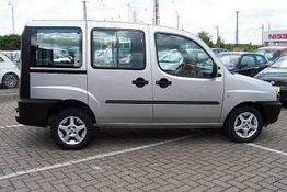Silberner Van auf einem Parkplatz, seitlich aufgenommen.