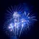 Blaues Feuerwerk erleuchtet den Nachthimmel mit funkelnden Lichtern und leuchtenden Strahlen.