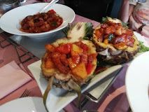 Tropische maaltijd geserveerd in halve ananassen met kleurrijke groenten en vlees.