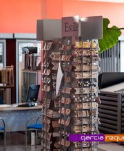 Expositor de materiales de construcción en una tienda con sillas azules y fondo colorido.