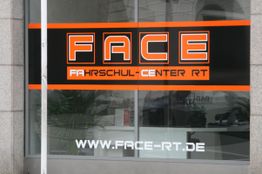 Schaufenster mit Schild "FACE Fahrschul-Center RT" und Website www.face-rt.de in Orange und Schwarz.