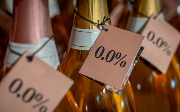 Abgebildet sind drei Sektflaschen mit den Etiketten "0,0% – Alkohol".