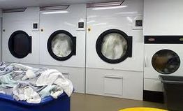 Industrial laundry machines with towels and linens in a laundry facility.