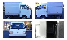 Camioneta blanca de costado, frente y con compartimento abierto, sobre fondo urbano.